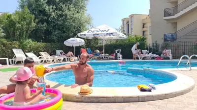 a man and two children playing in a swimming pool at Studio 39 in Sunny Beach