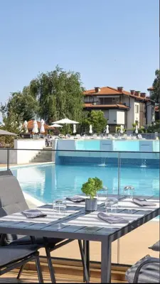 a table with glasses on it next to a swimming pool at Marina Forest in Sozopol
