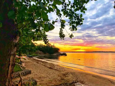 a view of a beach with a sunset in the background at Marina Forest in Sozopol
