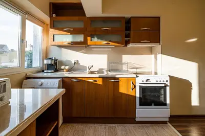 a kitchen with wooden cabinets and a white stove top oven at Primorski 2bdrm Central Apartment in Varna City