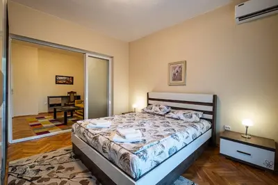 a bedroom with a large bed and a mirror at Primorski 2bdrm Central Apartment in Varna City