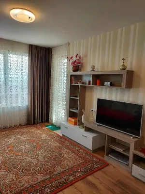 a living room with a flat screen tv and a rug at Прекраснные апартаменты с панорамным видом на море in Byala