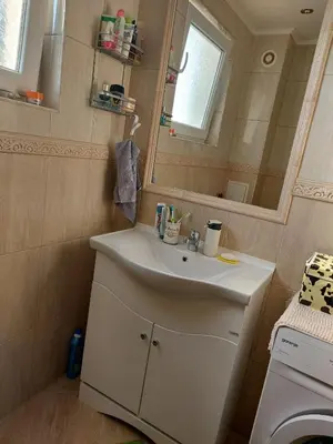 a bathroom with a white sink and a mirror at Прекраснные апартаменты с панорамным видом на море in Byala