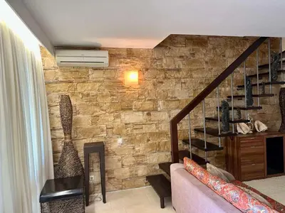a living room with a stone wall and a staircase at Oazis VIP Club in Sunny Beach
