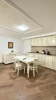 a kitchen with a white table and white cabinets at Penthouse Happy Moments 3 in Sunny Beach