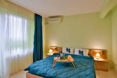 a bedroom with a bed with a table on it at Central Paradise - free parking in Varna City