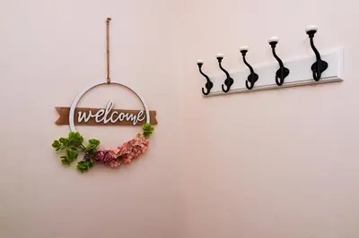 a welcome sign hanging on a wall with flowers at Central Paradise - free parking in Varna City