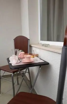 a small table with a chair next to a window at Central Apartment 5min to beach in Varna City