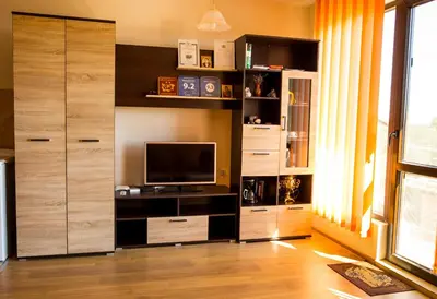 a living room with a large entertainment center with a television at DDenko Apartment in Burgas City
