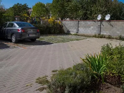 a car parked next to a brick parking lot at DDenko Apartment in Burgas City