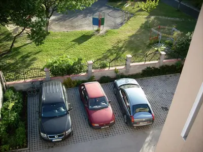 a group of three cars parked in a parking lot at DDenko Apartment in Burgas City