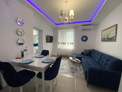 a living room with a blue couch and a table at Bluemoon-Apartment with Parking in Burgas City