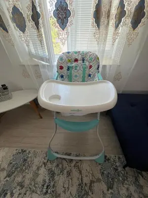 a blue and white high chair in front of a window at Bluemoon-Apartment with Parking in Burgas City