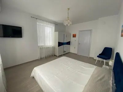 a bedroom with a white bed and a blue chair at Bluemoon-Apartment with Parking in Burgas City