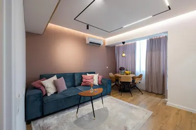 a living room with a blue couch and a table at OPAL Beachfront Apartment in Varna City