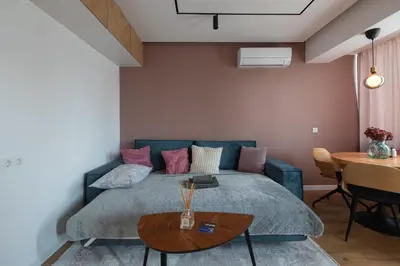 a bedroom with a blue bed and a table at OPAL Beachfront Apartment in Varna City