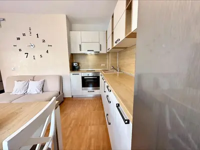a small kitchen with a clock on the wall at Panorama Dreams - Menada Apartments in Sveti Vlas
