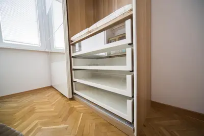 a closet with white shelves in a room with a window at Demokratsia bl 117 in Burgas City