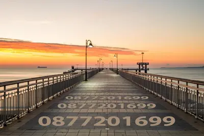 a pier stretches out into the ocean at sunset at Demokratsia bl 117 in Burgas City