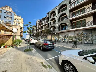 a car driving down a city street with buildings at Pomorie Bay - Menada Apatments in Pomorie
