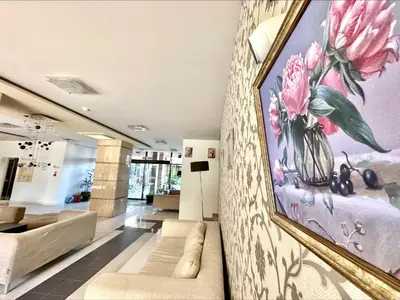 a living room with a painting on the wall at Pomorie Bay - Menada Apatments in Pomorie