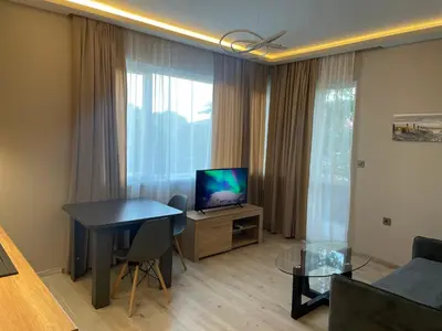 a living room with a television and a table and a couch at City Center Apartment 2 in Varna City