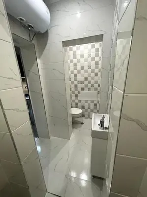 a white bathroom with a toilet and a sink at City Center Apartment 1 in Varna City