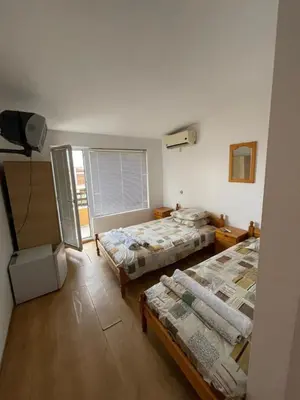a room with two beds and a television in it at Orange House in Sozopol