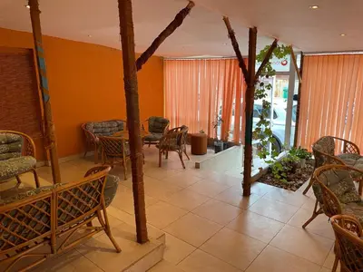 a living room with a table and chairs and windows at Orange House in Sozopol