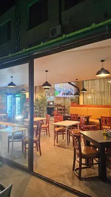 a dining room with tables and chairs and a cafeteria at Таунхаус с шикарной террасой in Sveti Vlas