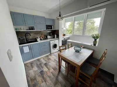 a kitchen with blue cabinets and a wooden table at Sunny Seaside Retreat in Burgas in Burgas City