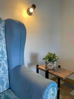 a blue chair sitting next to a table with a plant at Sunny Seaside Retreat in Burgas in Burgas City