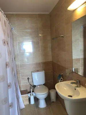 a bathroom with a white toilet and a sink at Комплекс Рич 2 in Ravda