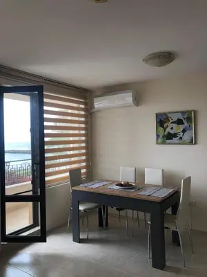 a dining room with a table and chairs and a window at Комплекс Рич 2 in Ravda