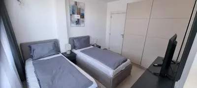 a small room with two beds and a television at Balcony Bliss: The Black Sea Pearl in Sveti Vlas