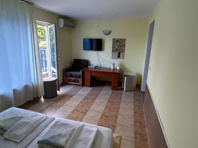 a bedroom with a bed and a desk and a chair at Hotel North in Primorsko
