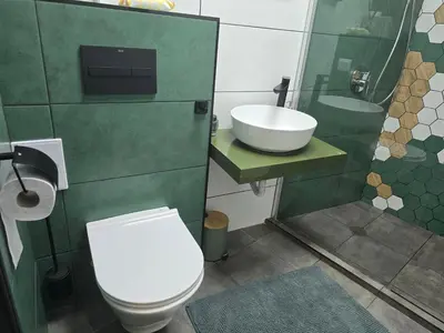 a bathroom with a white toilet and a sink at The Atelier in Burgas City