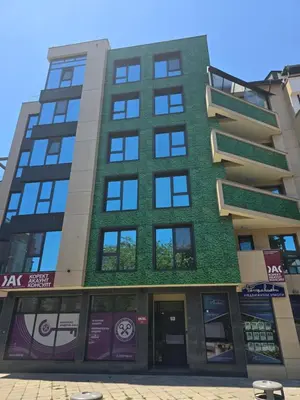 a tall building with a green facade at The Atelier in Burgas City