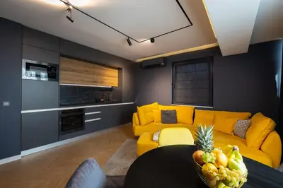 a living room with a yellow couch and a table at TOPAZ Beachfront Apartment in Varna City