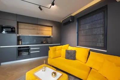 a living room with a yellow couch and a table at TOPAZ Beachfront Apartment in Varna City