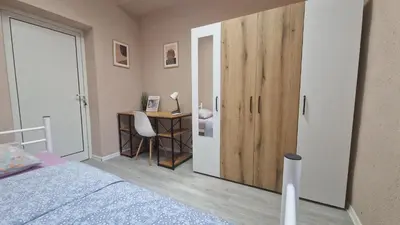 a bedroom with a bed and a desk with a cupboard at Lambo's Corner Varna - Guest Rooms in Varna City