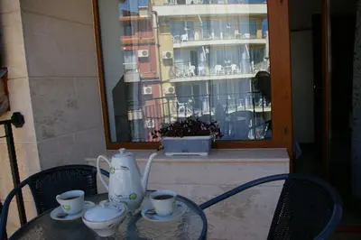 a table with cups and a vase on it at Sea View Apartments in Sozopol