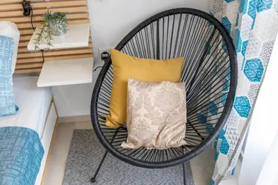 a wicker chair with a pillow in a room at Roman Thermae Central Studio in Varna City