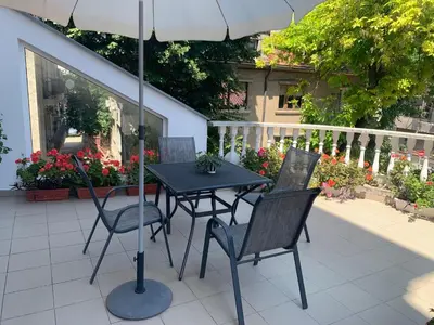 a table and chairs with an umbrella on a patio at Florence Studio in Varna City