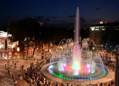 a fountain in the middle of a city at night at Florence Studio in Varna City