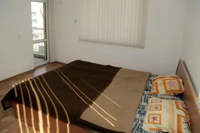a large bed in a room with a window at Kirovi Apartment in Primorsko