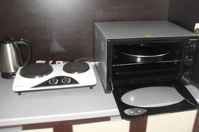 a stove top oven sitting next to a microwave at Kirovi Apartment in Primorsko