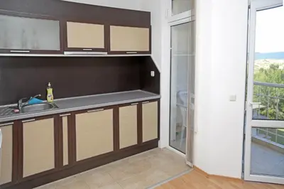 a kitchen with a sink and a counter with a window at Kirovi Apartment in Primorsko
