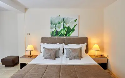 a bedroom with a large bed with two lamps at Hotel Venus in Sunny Beach