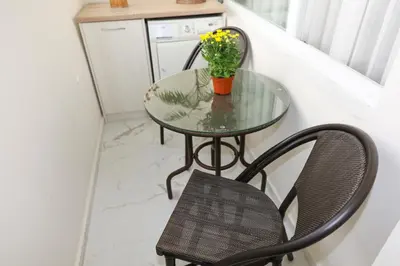a glass table and a chair with a vase of flowers at Magnolia in Burgas City